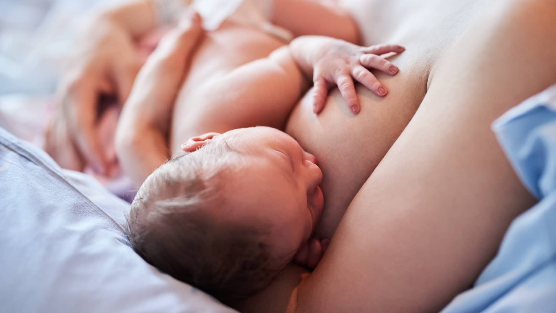 Madre dando el pecho a su bebé tras conocer los muchos beneficios e la lactancia materna