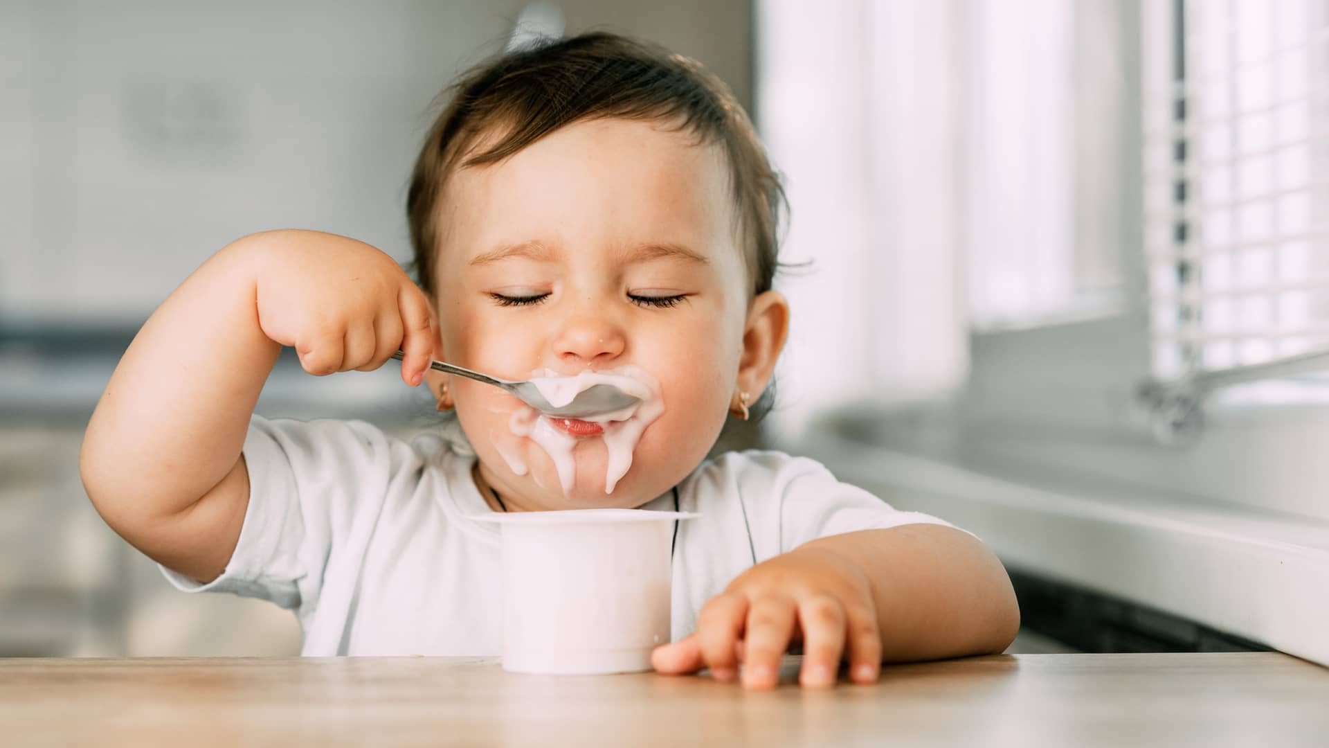un bebe comiendo un yogur especifico para bebes
