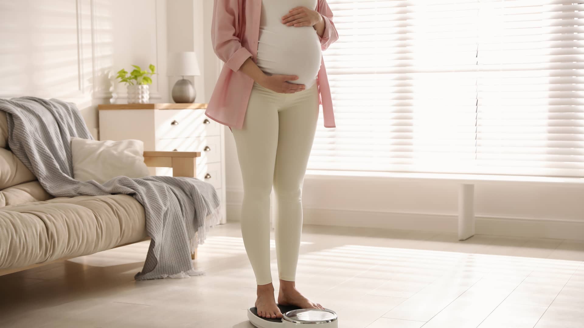 Mujer embarazada pesandose para comprobar con su calculadora de peso la correcta evolución del embarazo
