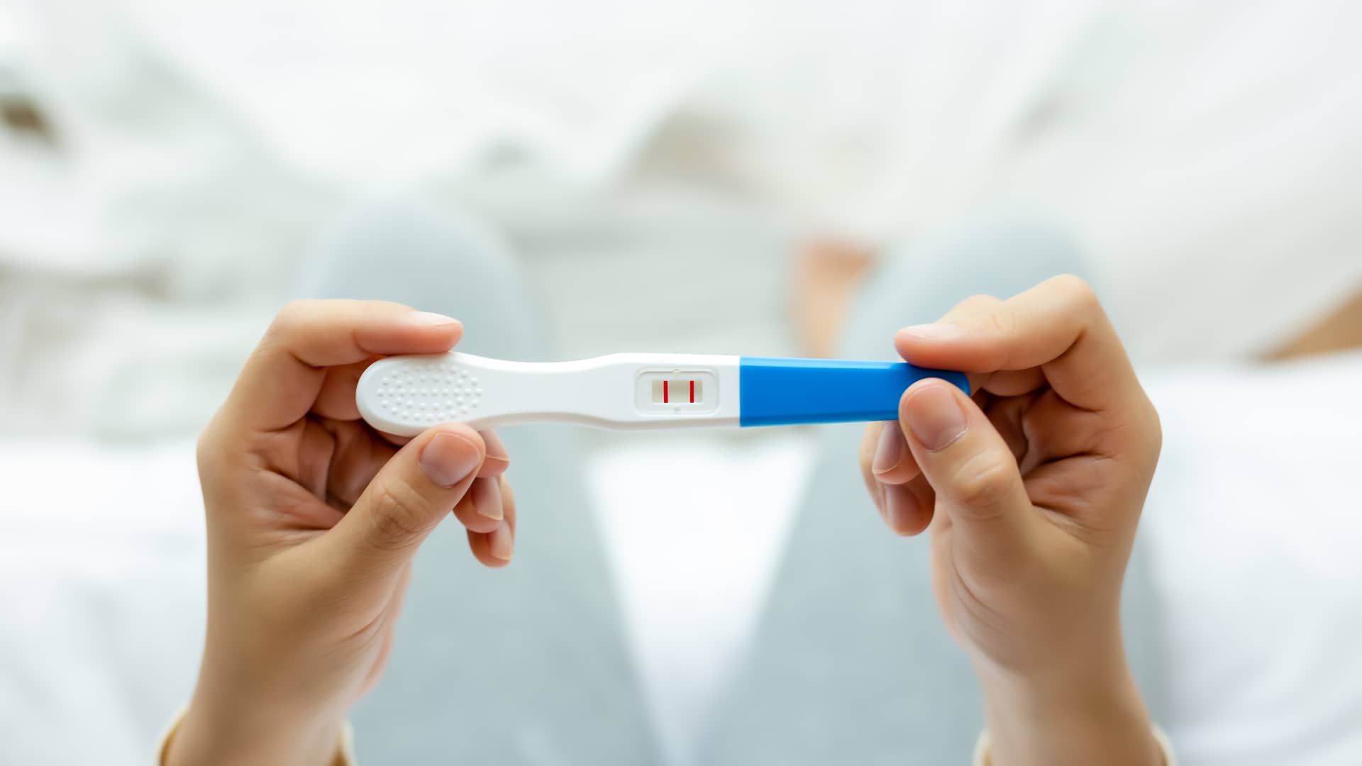 Mujer sostiene un test positivo de embarazo