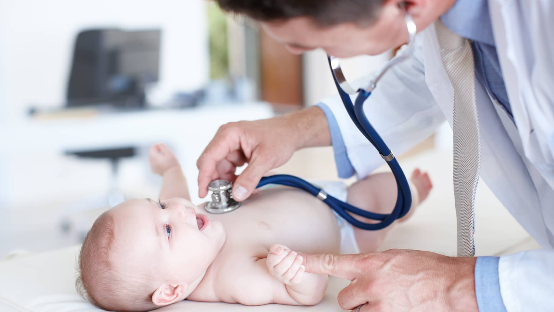 Pediatra revisando la salud de un sonriente bebé